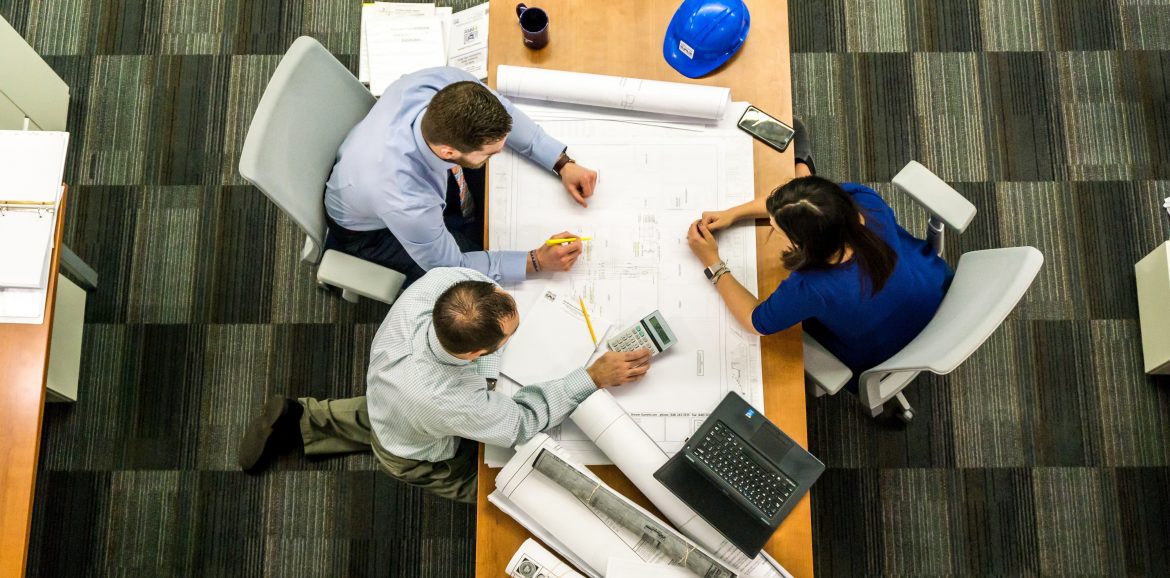 Three people having a meeting at a desk