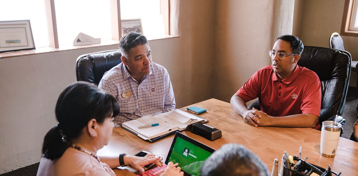 People sitting at a desk having a meeting